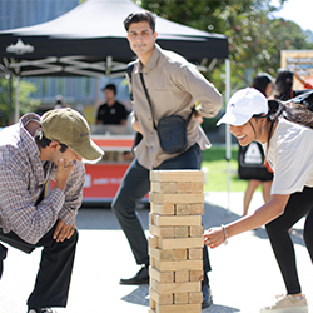 Three students playing jenga