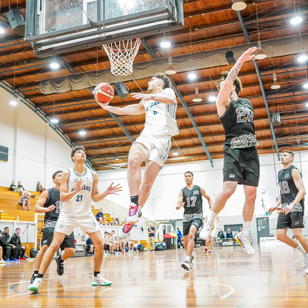 A team of students playing basketball in a sports hall