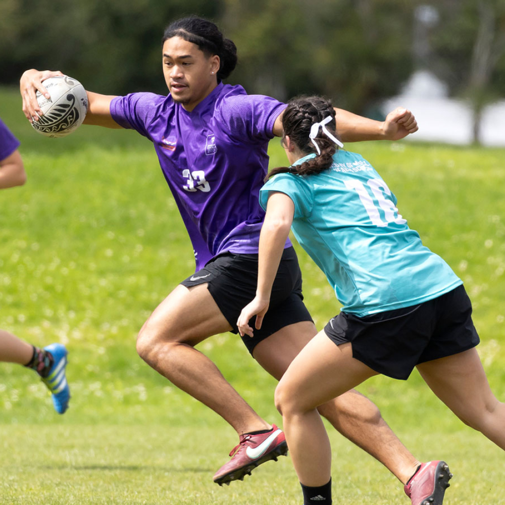 Students playing Interfaculty touch rugby on a field