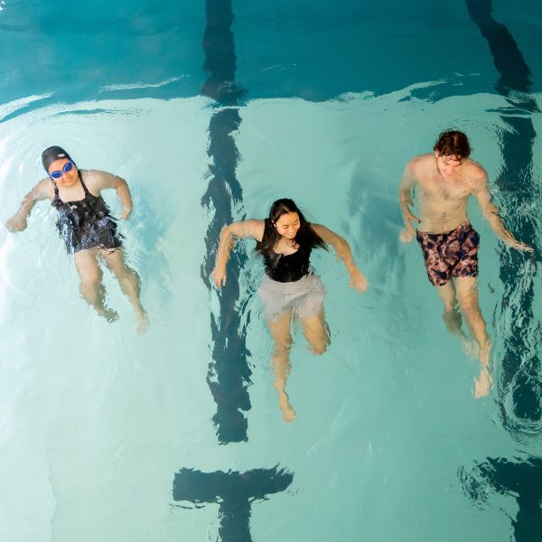 Aerial shot of the Hiwa pool looking down at three students in the pool  