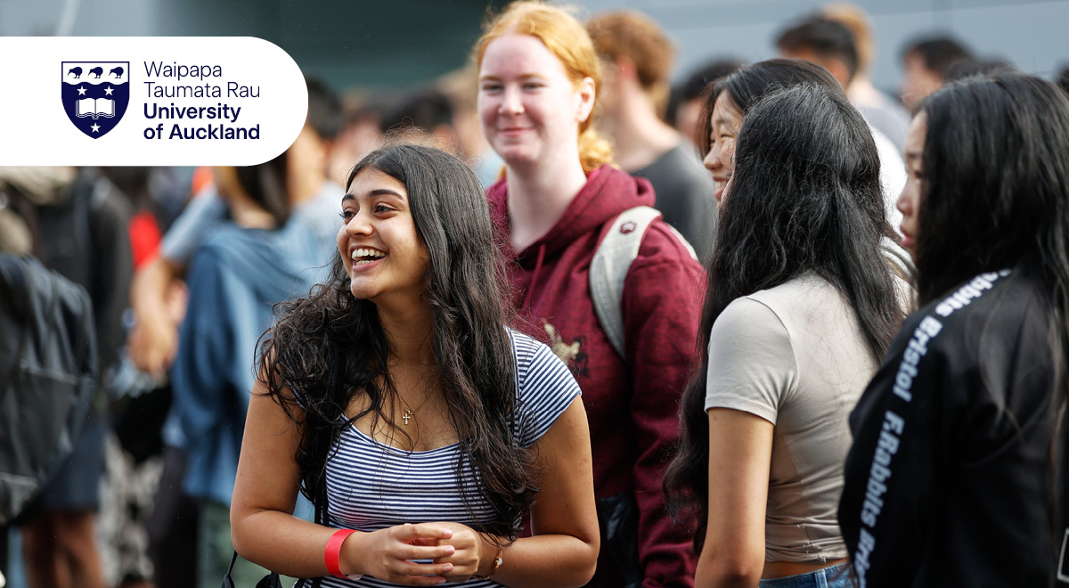 Several students standing outside smiling and chatting to each other.